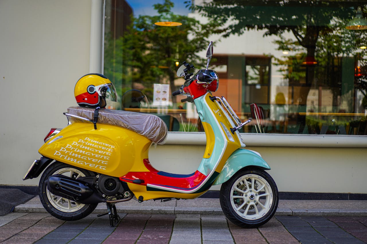 Vibrant Vespa scooter with helmet parked beside a glass window showcasing urban lifestyle.